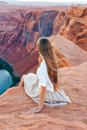 Happy girl on the edge of the cliff at Horseshoe Band Canyon in Page, Arizona. Adventure and tourism concept. Beautiful nature in USAの写真素材