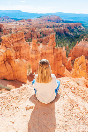Little girl in Bryce Canyon hiking relaxing looking at amazing view during hike on summer travel in Bryce Canyon National Park, Utah, United States.の写真素材