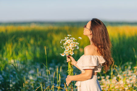 Portrait of girl on a chamomile field in summerの写真素材