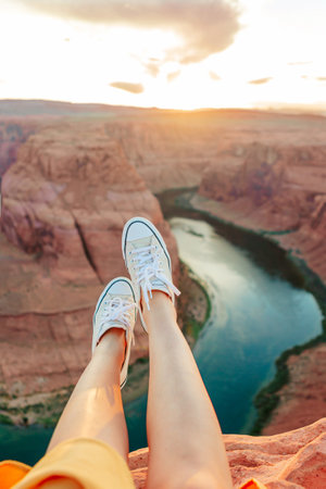 Legs on the edge of the cliff at Horseshoe Band Canyon in Page, Arizona. Adventure and tourism concept. Beautiful nature in USAの写真素材