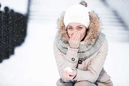 Portrait of a beautiful girl who warms the frozen hand nose winterの写真素材