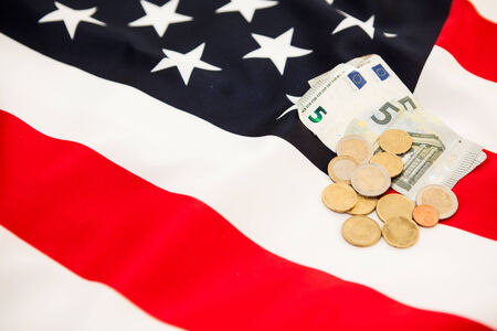 5 Euro currency and coins lie on the background of the flag of the United Statesの写真素材