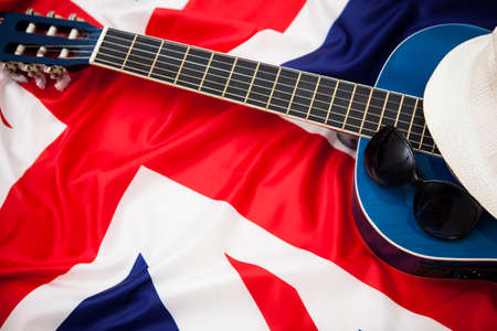 Guitar, hat and glasses on the background of the flag of Britainの写真素材