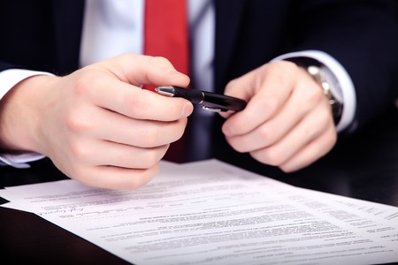 Businessman in red tie doubts sign a contract.