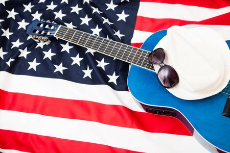 US pro musicians. Guitar lies on the flag of Britain. Glasses on white hatの写真素材