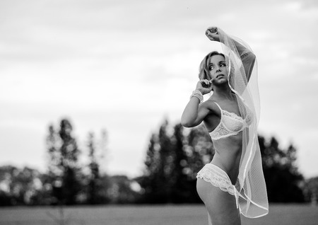 Beautiful Young Woman in brown raincoat. Against backdrop of buildingの写真素材