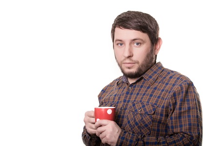 A bearded man in a plaid shirt with red cup in his hands.の写真素材