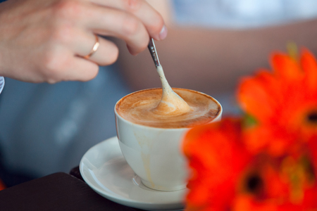 hands of the groom and the bride and coffee cups on the table.の写真素材