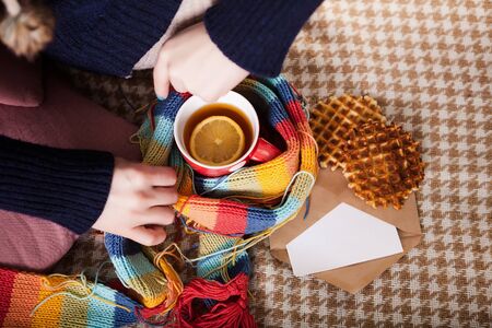young woman with christmas cookie and cup of hot tea
