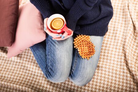 warm cup of hot coffee warming in the hands of a girl.の写真素材