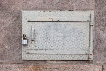 A locked basement window iron doorの写真素材