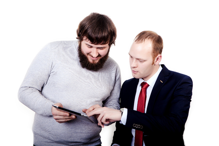 Business people planning work in office working on tablet computer, left guy shows to another man his planの写真素材