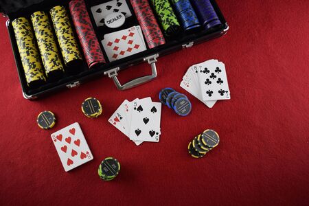 Chips and poker cards in a black case with red background