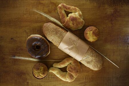 donut, baguette and bread on a wood background