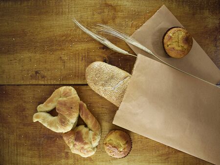baguette in a paper bag, wheat bread on woodの写真素材