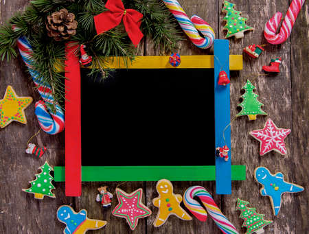 Winter frame:wooden board surrounded by homemade cookies and lollipopsの写真素材