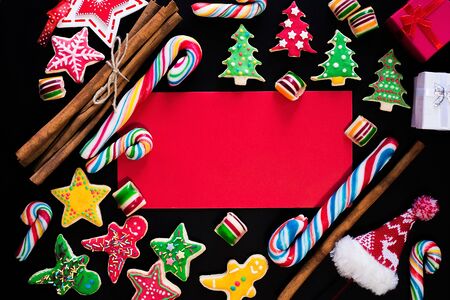 Winter frame: christmas decoration surrounding red envelope on black backgroundの写真素材