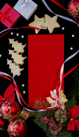Winter frame: christmas decoration surrounding red envelope on black backgroundの写真素材