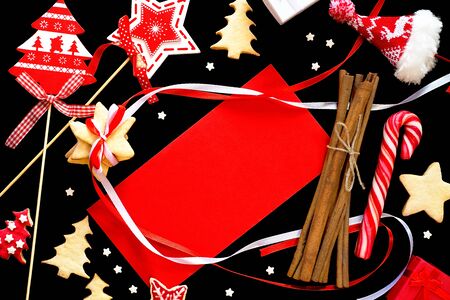Winter frame: christmas decoration surrounding red envelope on black backgroundの写真素材