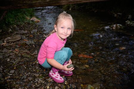 Little girl is playig at the creekの写真素材