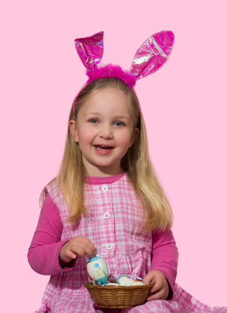 Cute little girl holding basket full of eggsの写真素材
