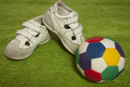 White children sneakers on green backgroundの写真素材