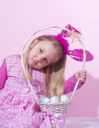 Cute little girl holding basket full of eggsの写真素材