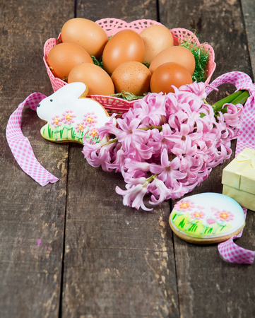 Easter decoration with flowers,cookies and eggs on a wooden tableの写真素材