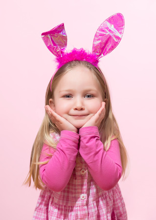 Cute little girl dressed up like a bunny is posingの写真素材