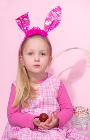 Cute little girl dressed up like a bunny is posingの写真素材