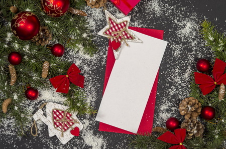 Winter frame: christmas decoration surrounding red envelope on black backgroundの写真素材