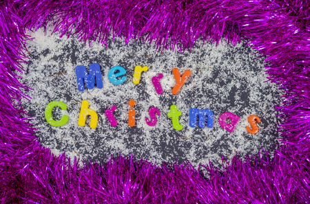 Colorful christmas title surrounded with garland on black backgroundの写真素材