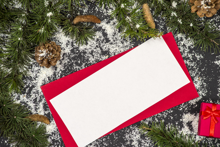 Winter frame: christmas decoration surrounding red envelope on black backgroundの写真素材