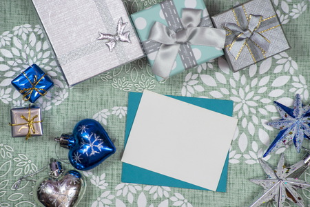 Winter frame: christmas decoration surrounding blue envelope and presentsの写真素材