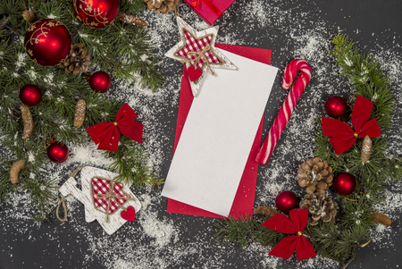 Winter frame: christmas decoration surrounding red envelope on black backgroundの写真素材