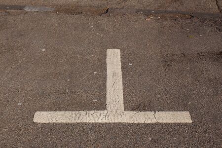 Close up of a old, dirty and fading white marking in a empty parking lotの写真素材