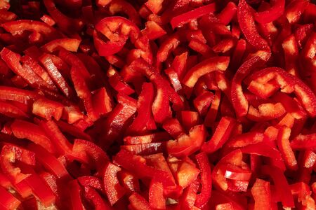 Small cut slices of red pepper for red backgroundの写真素材