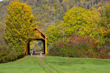 Path leading to an old traditional wooden roof covered bridge