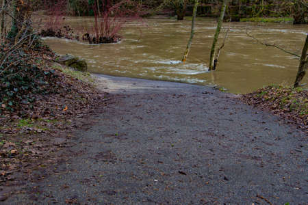 Pedestrian walkway leading into the floods of a river