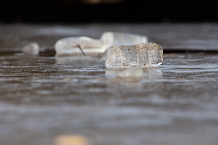 Side view of ice block laying on ice surface, selective focus