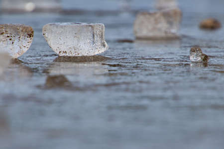 Side view of ice block laying on ice surface, selective focus