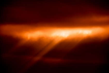 Abstract orange background with cloud texture and sunrays
