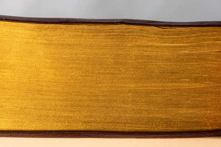 Close up of pages of a book with golden edges, golden texture backgroundの写真素材