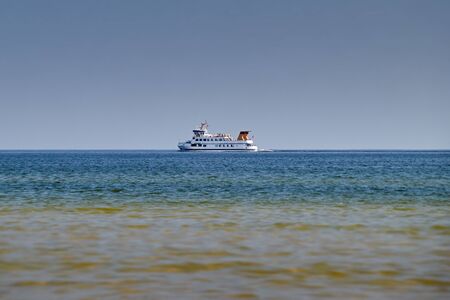 a liner ship sailing through the blue green water at the Baltic Sea coastの写真素材