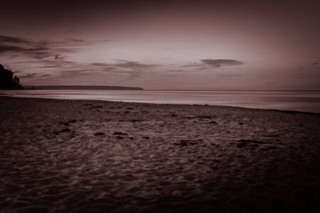 Scary beach scene. A sandy beach on the coast in dramatic dark ominous scenery and atmosphere.