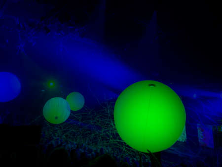 Abstract blue black background with three green glowing balls and lens flares