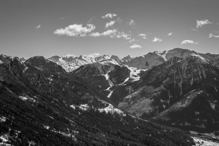 View over the beautiful snowy Val di Fassa in the Dolomites from the Rosengarten ski area, black and white panoramaの写真素材