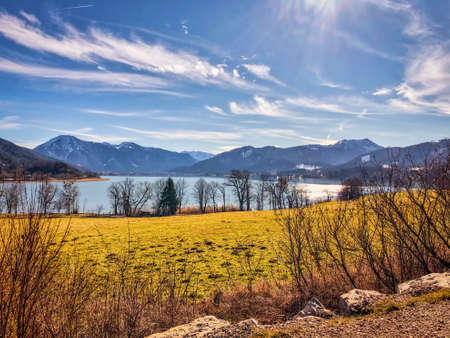 View of the lake Tegernsee in Bavaria, Germany in autumn from the town of Gmund on the north side with beautiful weather, blue sky, sunshine and cloudsの写真素材