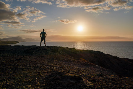 Sunset panorama with man on the Canary Islands, view of the sea and the coast in the evening light...