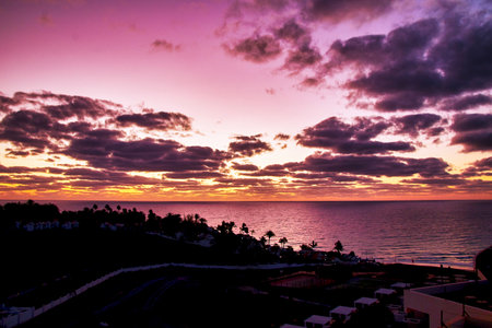 Morning light, the sun rises on Jandia beach, bright purple colored sky and clouds, Fuerteventura